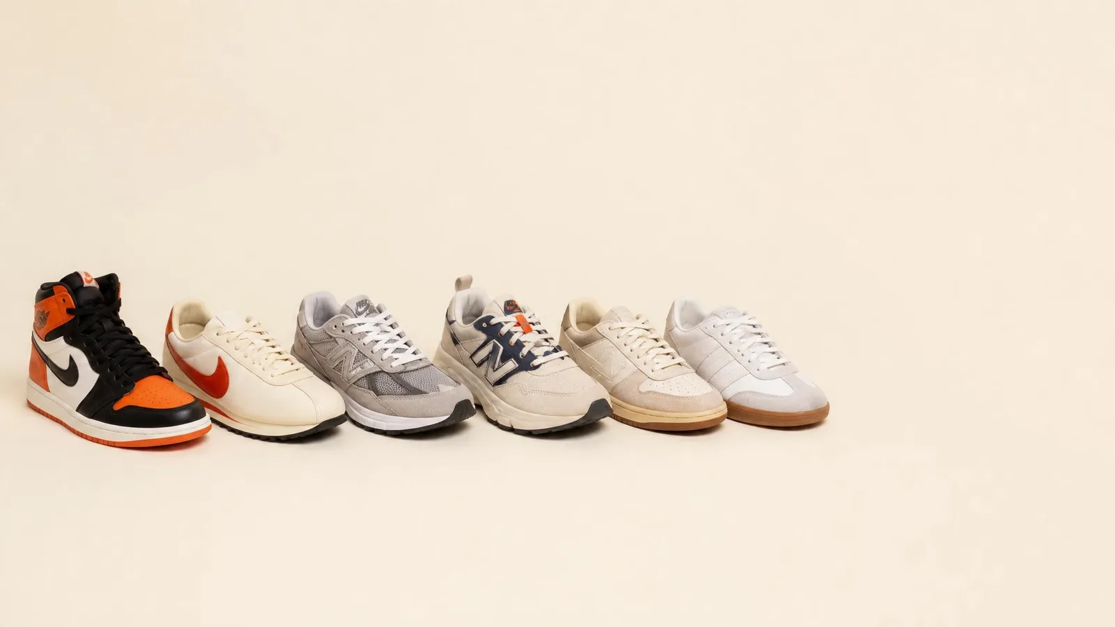A curated side-profile row of classic sneaker silhouettes arranged on a cream-coloured surface, representing a thoughtfully built personal sneaker collection.