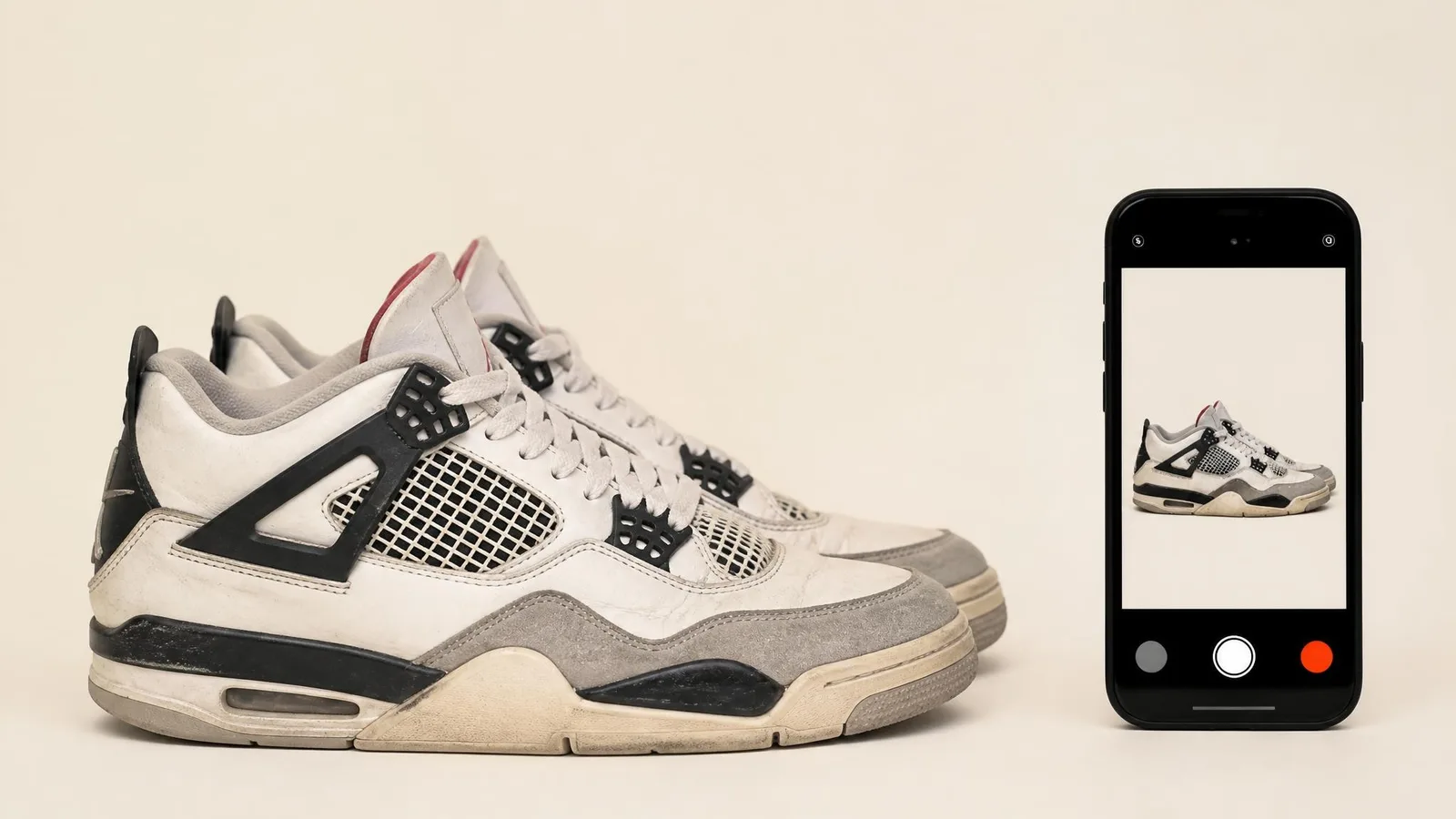 A pair of pre-owned sneakers beside a smartphone with the camera open, illustrating the practice of photographing secondhand purchases to create a timestamped provenance record.
