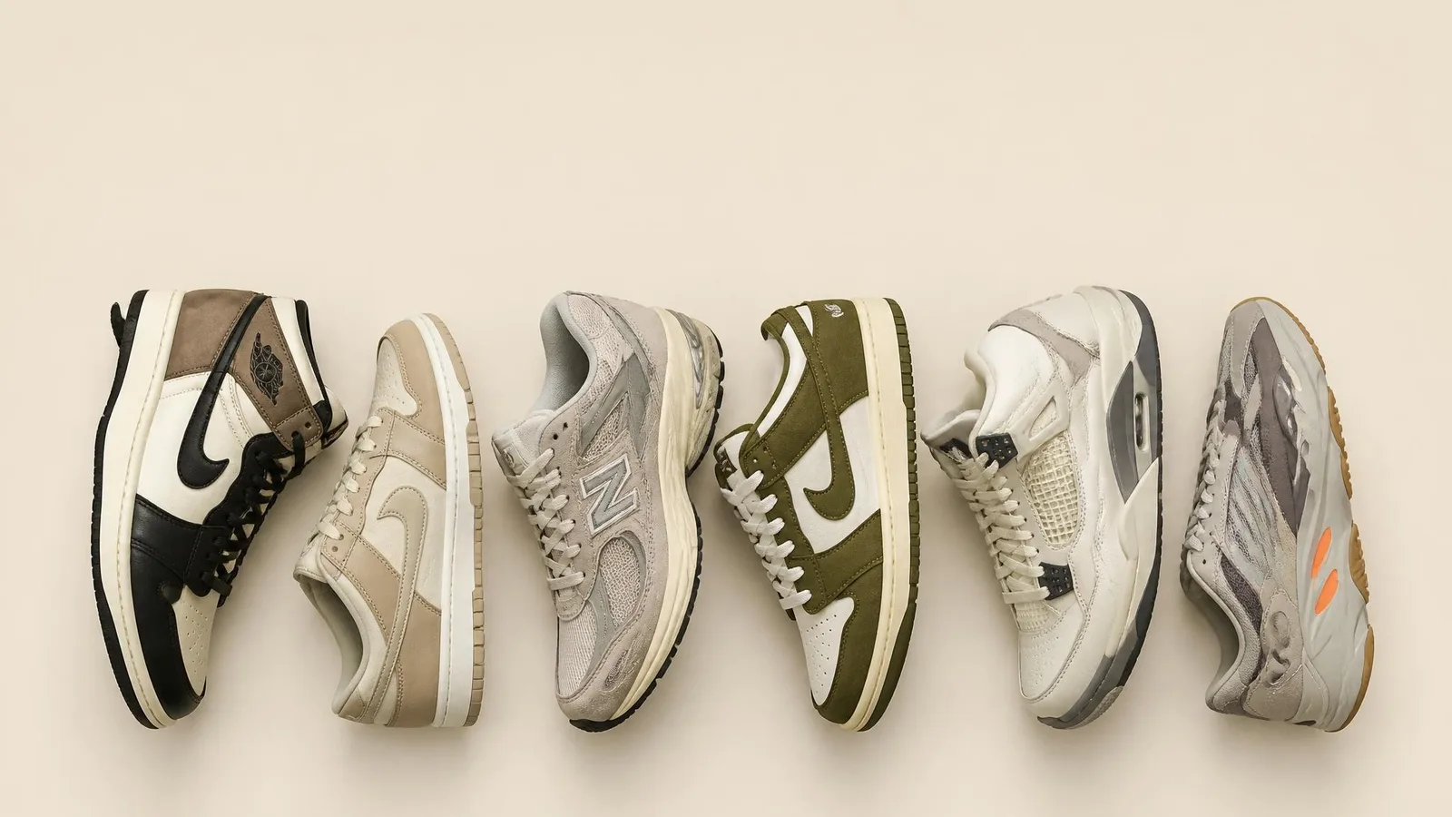 Flat-lay of five collector sneakers including a Jordan 1 and a Dunk arranged in a row on a cream background, shot from overhead