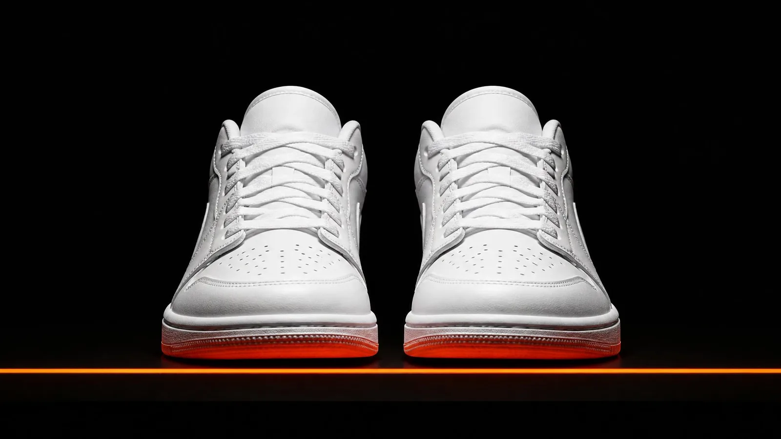 Two matching white sneakers displayed side by side in symmetrical front-profile view against a near-black background with a warm orange accent glow beneath them, representing a catalogued sneaker collection.