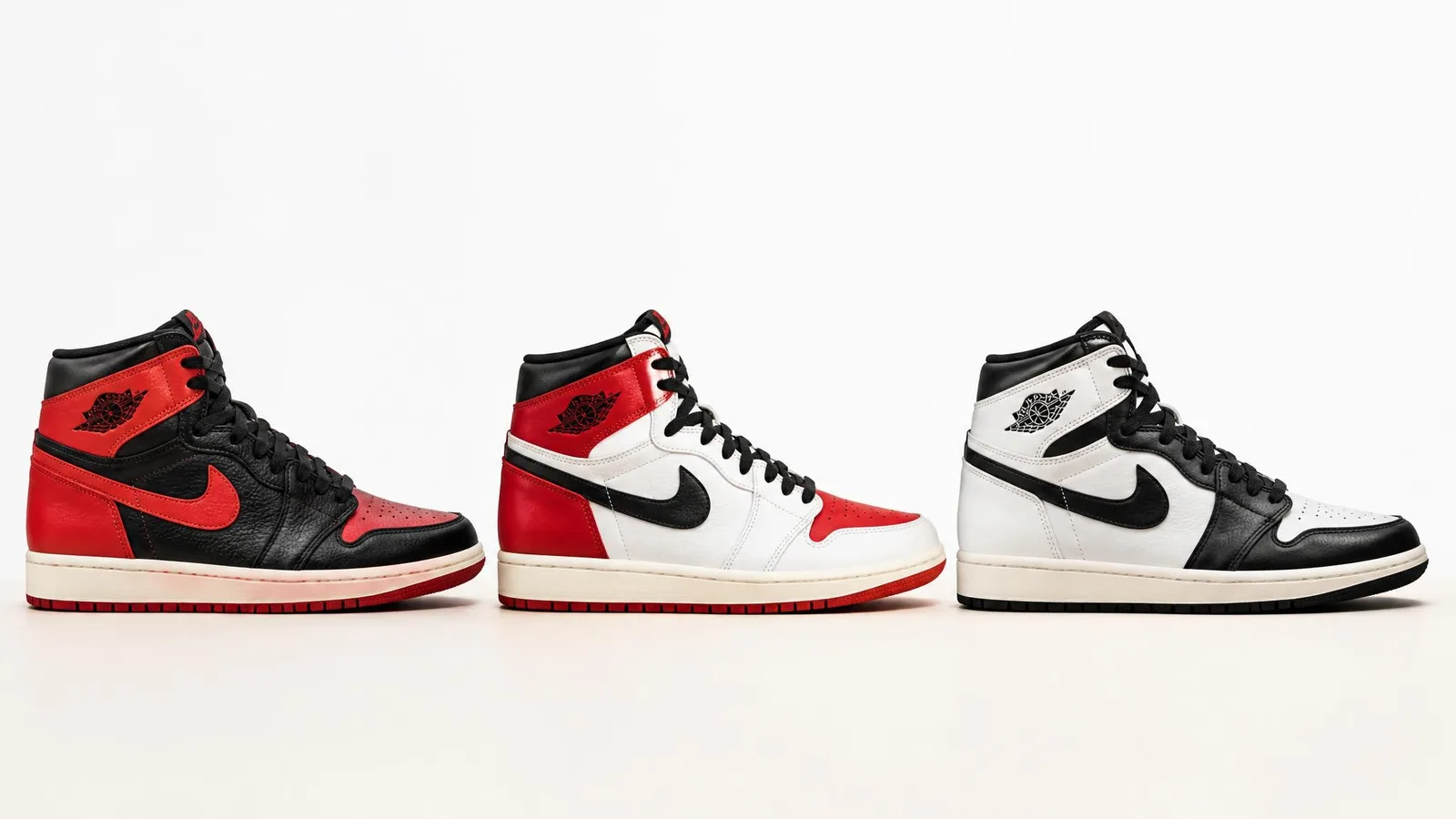 Three sneakers arranged side by side in side profile against a white background, showing three different colorways including black and red, white red and black, and white and black.