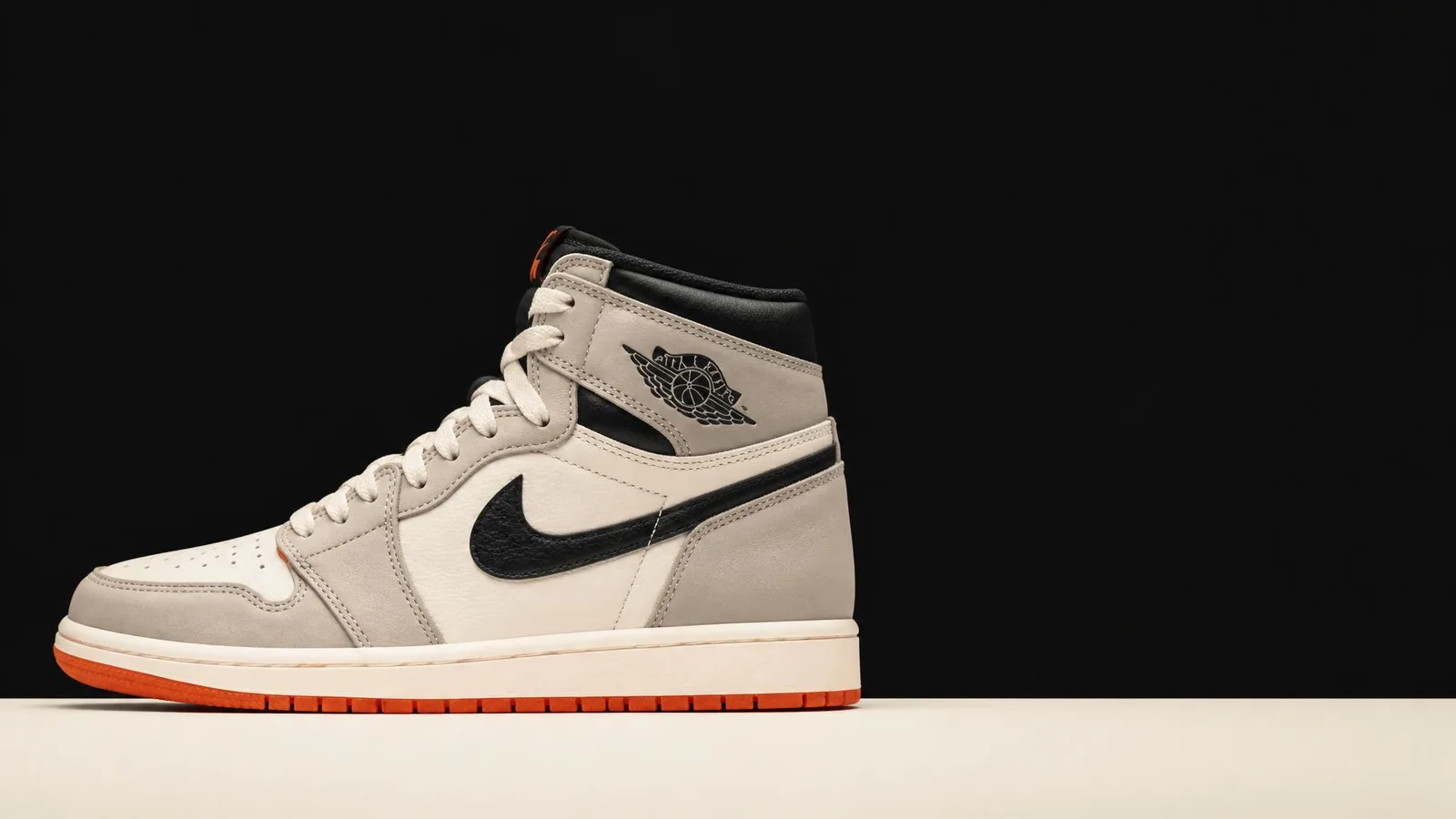 A deadstock high-top sneaker photographed in catalogue side-profile style against a near-black background, with warm orange accent lighting and space for a headline overlay on the right.